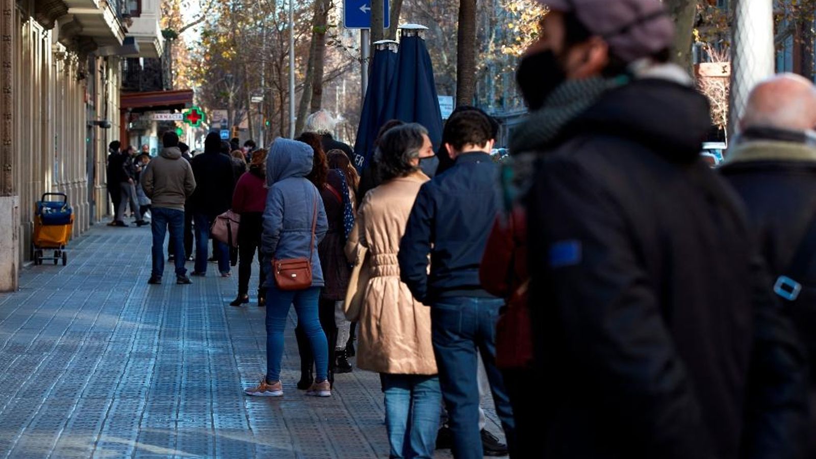 Una cua de persones esperen per a realitzar-se un test PCR en un laboratori de Barcelona.