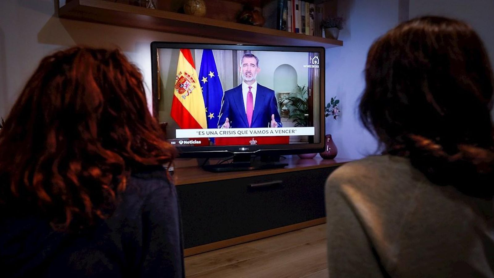 Dues persones atenen al missatge televisat del rei a Sevilla