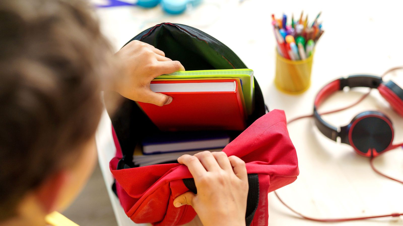 Imatge d'arxiu d'un xiquet amb la seua motxilla i material escolar