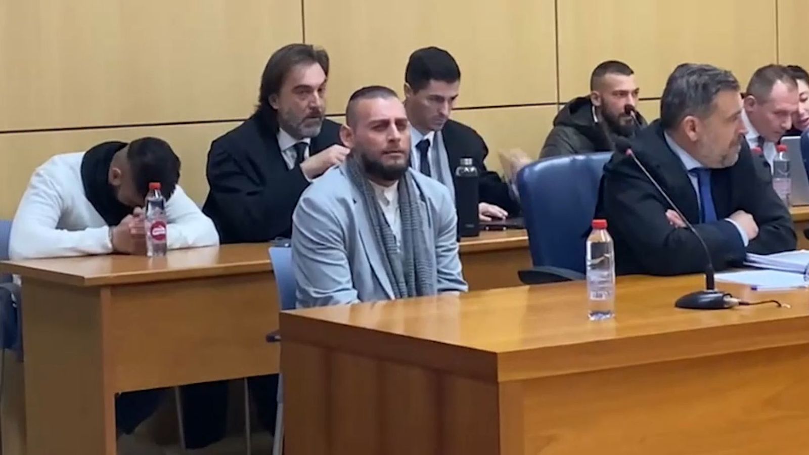 El tres acusats durant el juí: l'home blanc que baixa el cap, el de jaqueta i bufanda i el que hi ha en el segon banc, a l'extrem dret