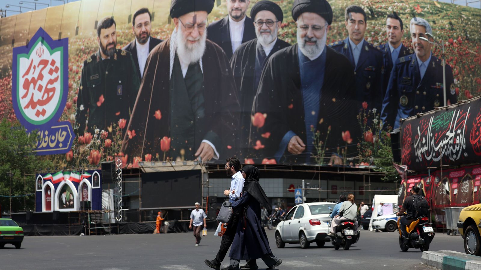 Iranians caminen davant d’una tanca publicitària amb imatges del difunt líder suprem iranià, l’aiatol·là Ali Khamenei, i del difunt expresident iranià Ebrahim Raisi a Teheran