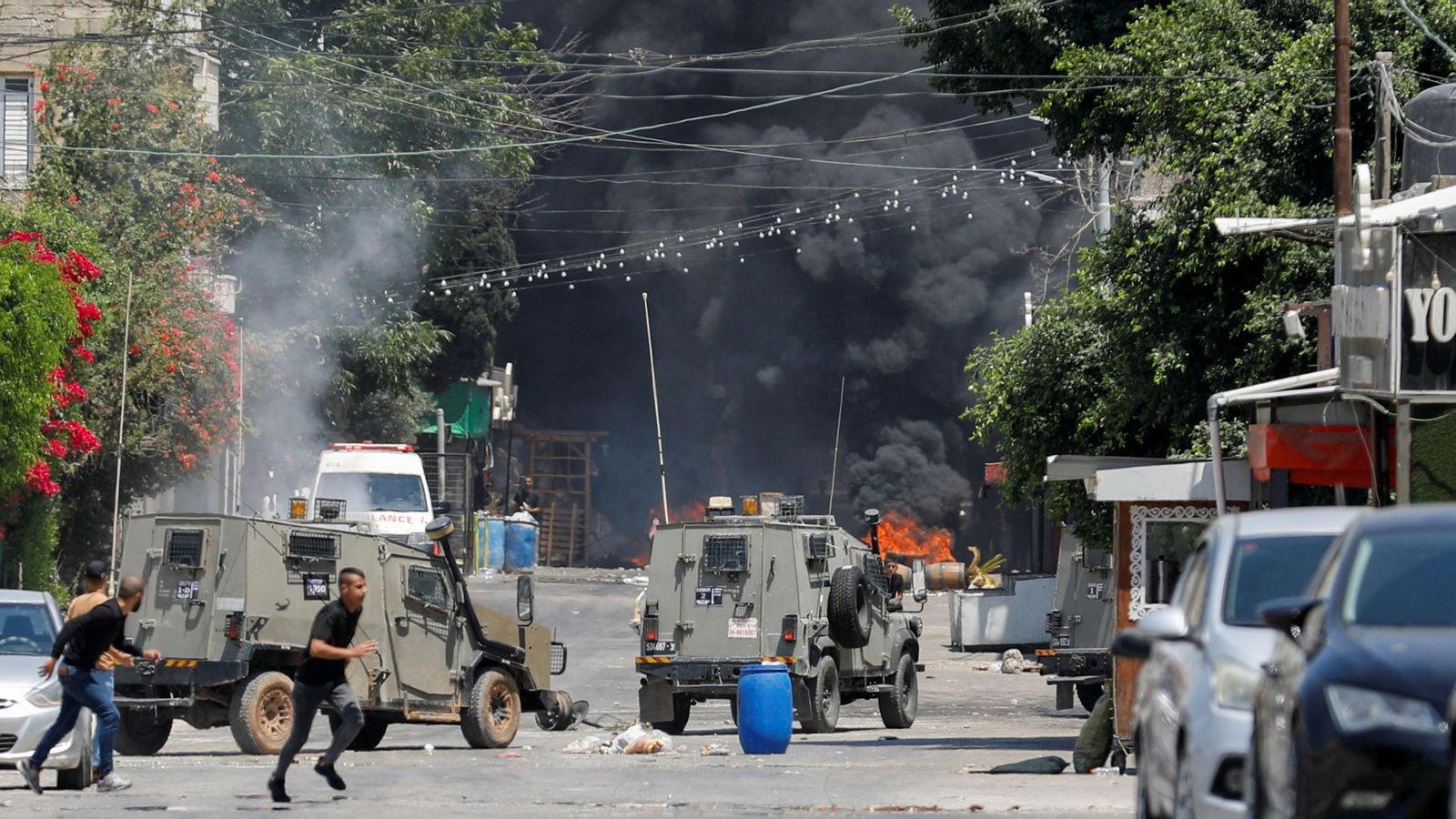 Un grup de palestinians corre en busca de recer en mig dels enfrontaments amb les forces israelianes