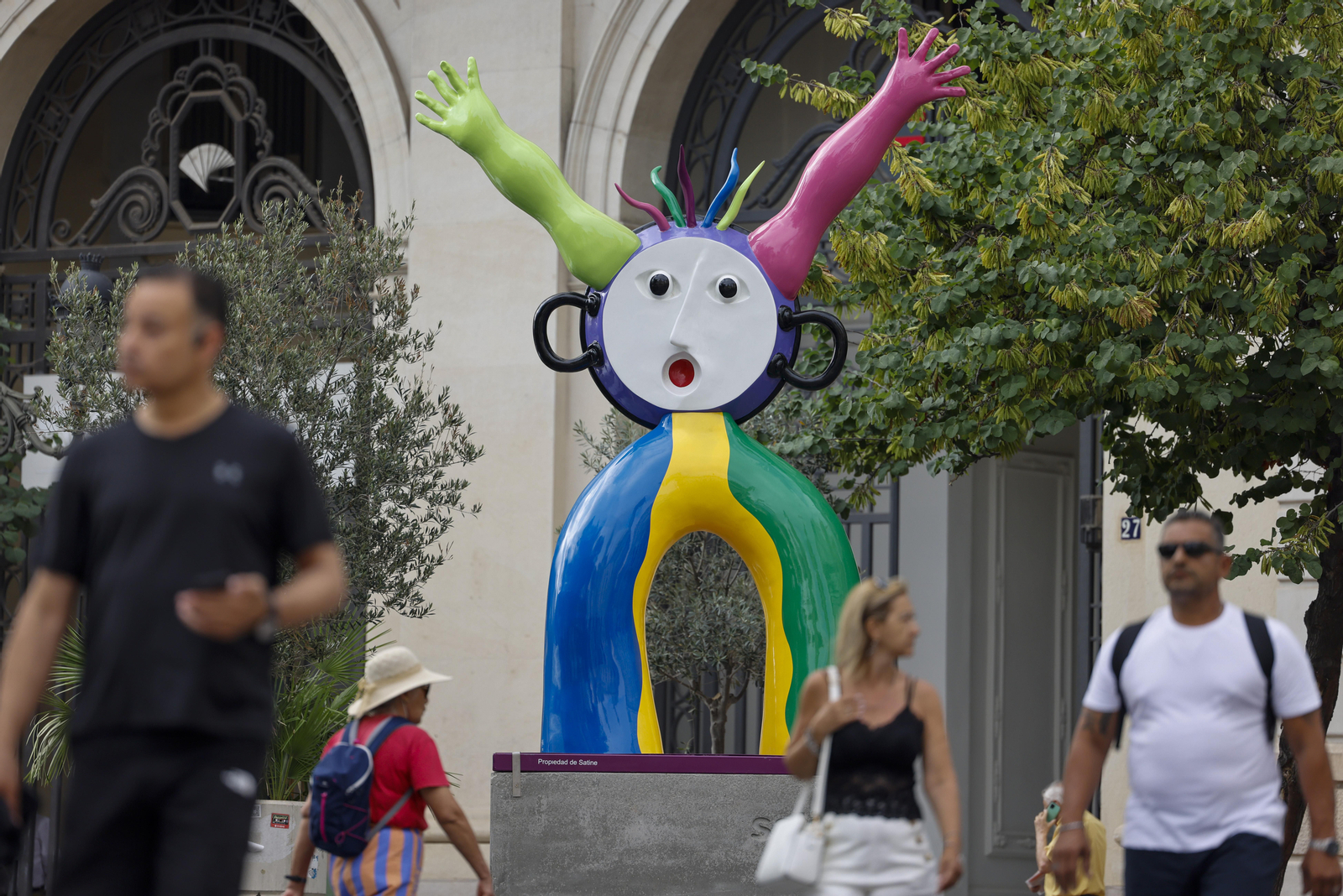Diverses persones transiten al costat de l'escultura ‘La paella’