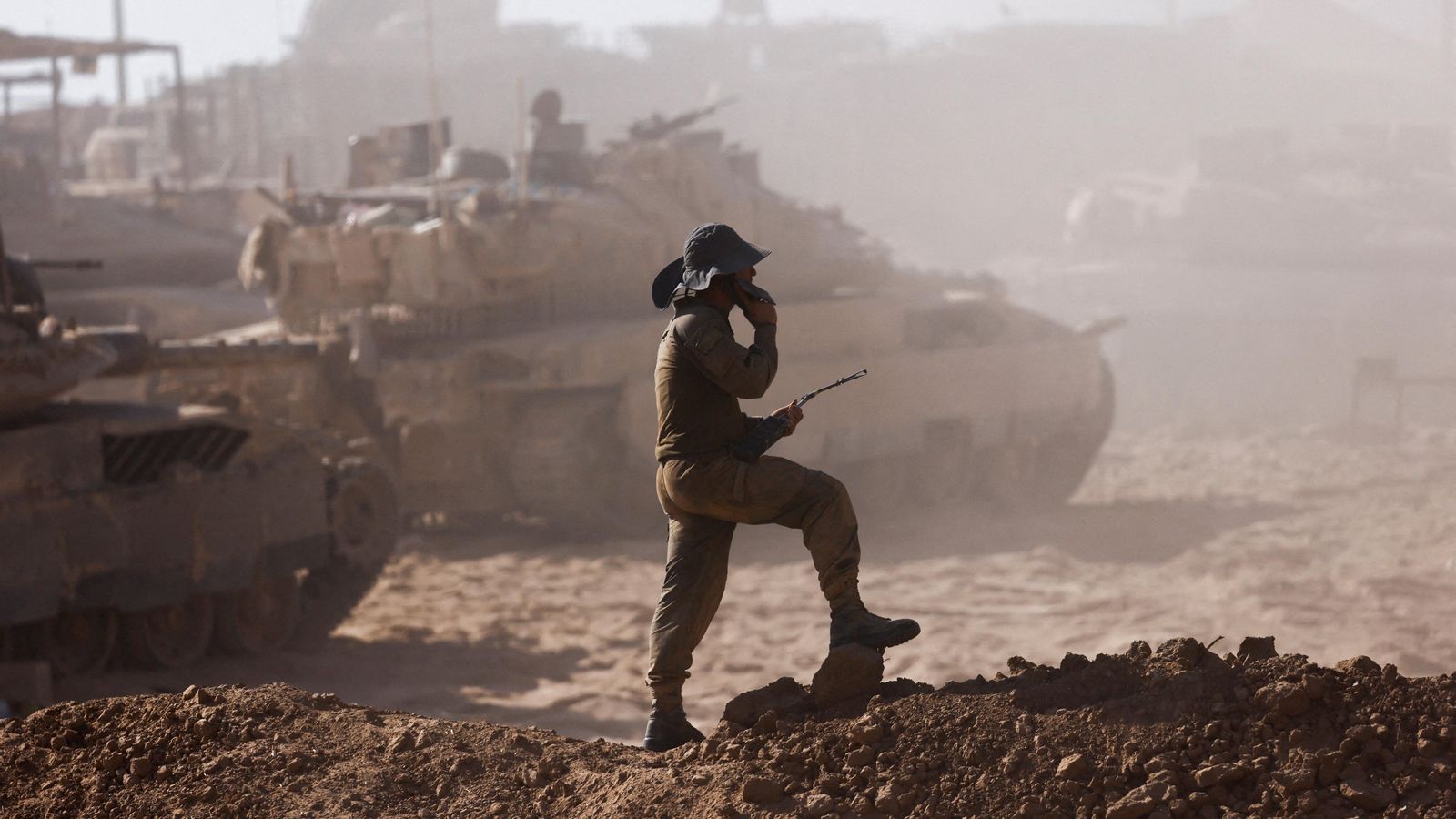 Un soldat israelià al costat de vehicles militars vist des del costat israelià de la frontera entre Israel i Gaza.