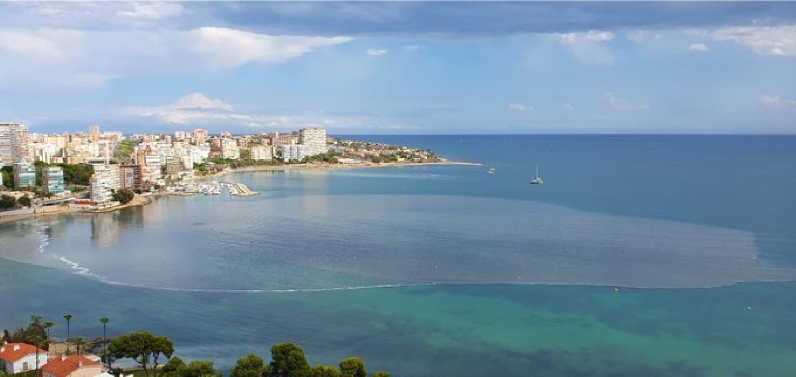 Platja de l'Albufereta d'Alacant i al fons el Cap de l'Horta amb una taca de vessaments