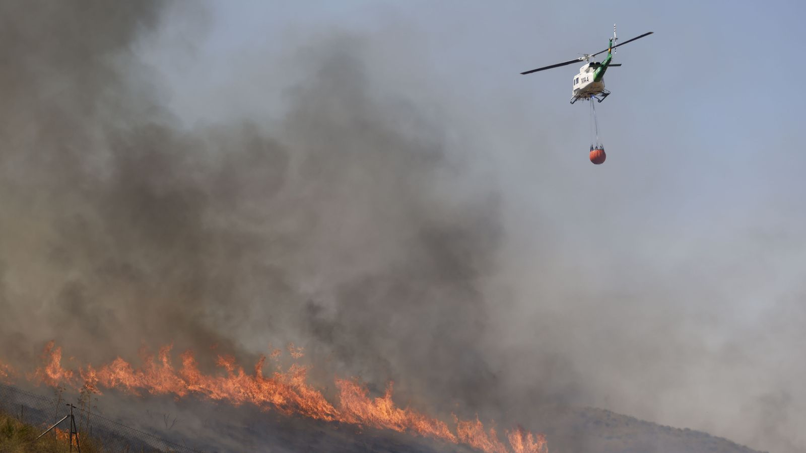 Un helicòpter participa en les tasques d'extinció de l'incendi