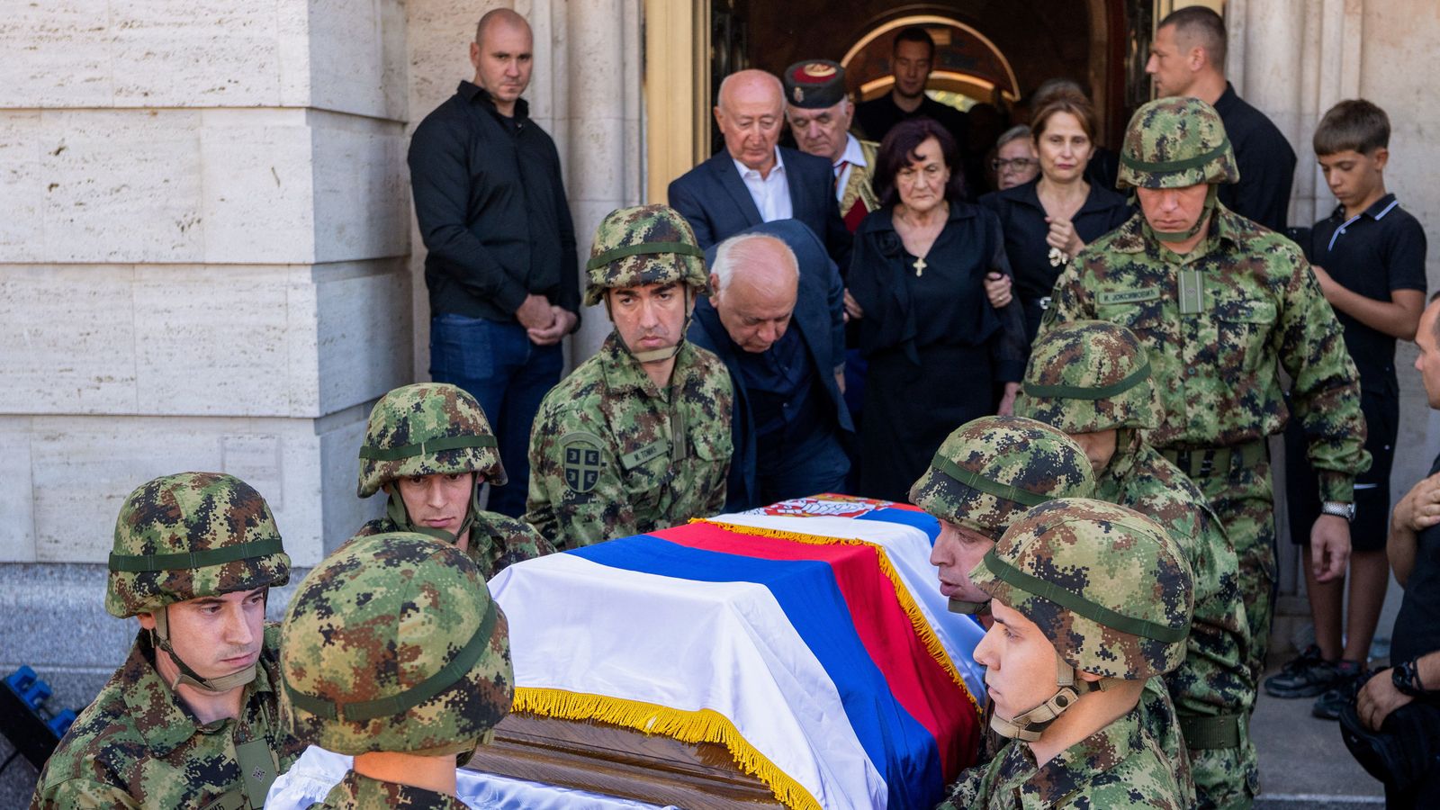 Militars serbis porten el féretre amb les restes de Ratklo Mladic cap al cementeri amb una bandera del país