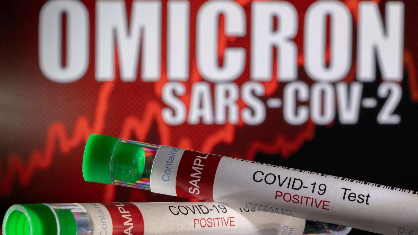 Una mostra positiva de covid-19 davant d'un rètol en què es llig "òmicron SARS-CoV-2"