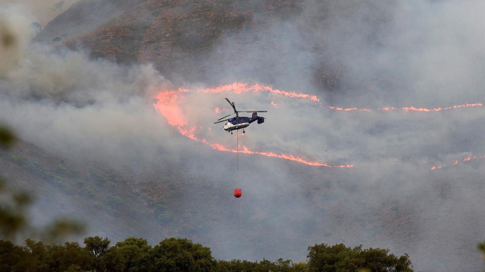 Diversos mitjans aeris treballen per a sufocar les flames de l'incendi declarat a Sierra Bermeja, Màlaga