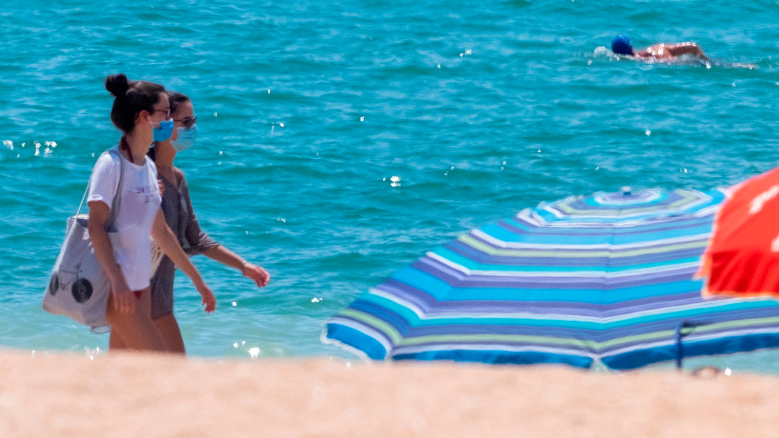 Dos joves passegen per la vora de la mar a Andalusia, on les mascaretes són obligatòries, fins i tot, a la platja