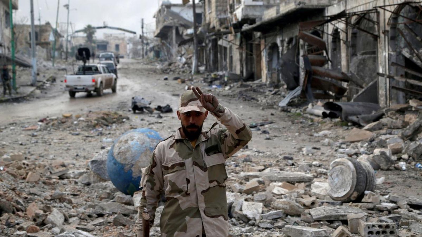Un soldat de l'exèrcit siri saluda a càmera a les ruïnes de Maarat al-Numan, a l'oest del país