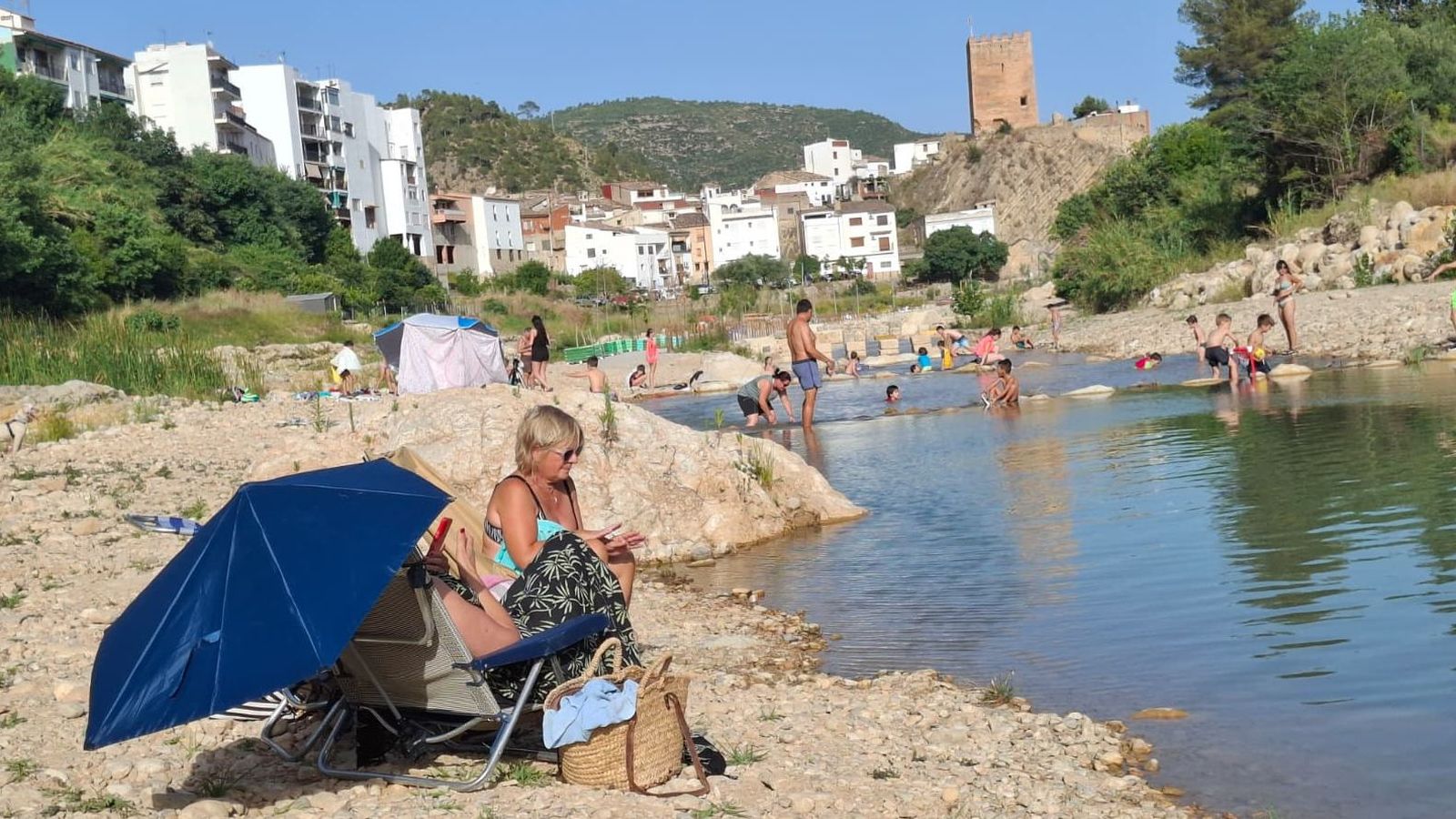 Diverses persones es refresquen este dimarts en el riu a Sot de Xera