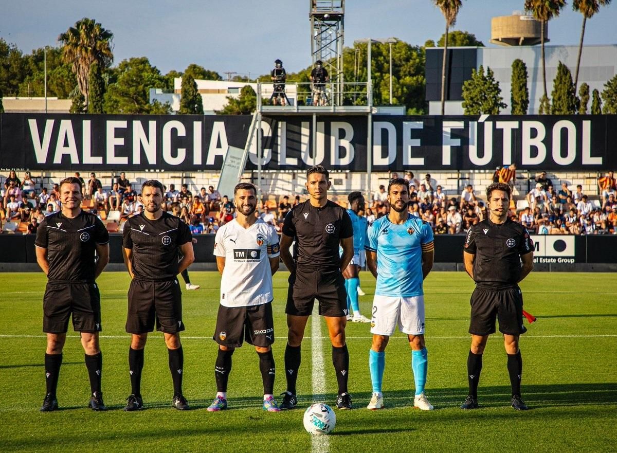 Els capitans de València i Castelló, José Luis Gayà i Salva Ruiz, posen amb l'equip arbitral abans del partit