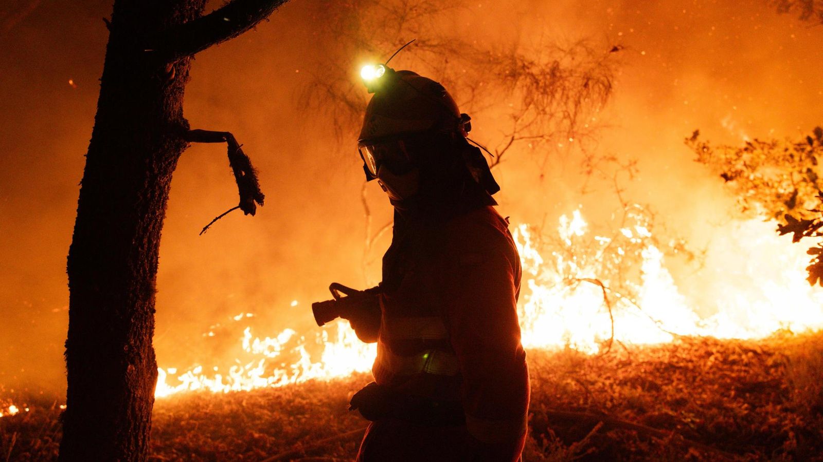 Un bomber lluita contra el foc a Oimbra, Ourense