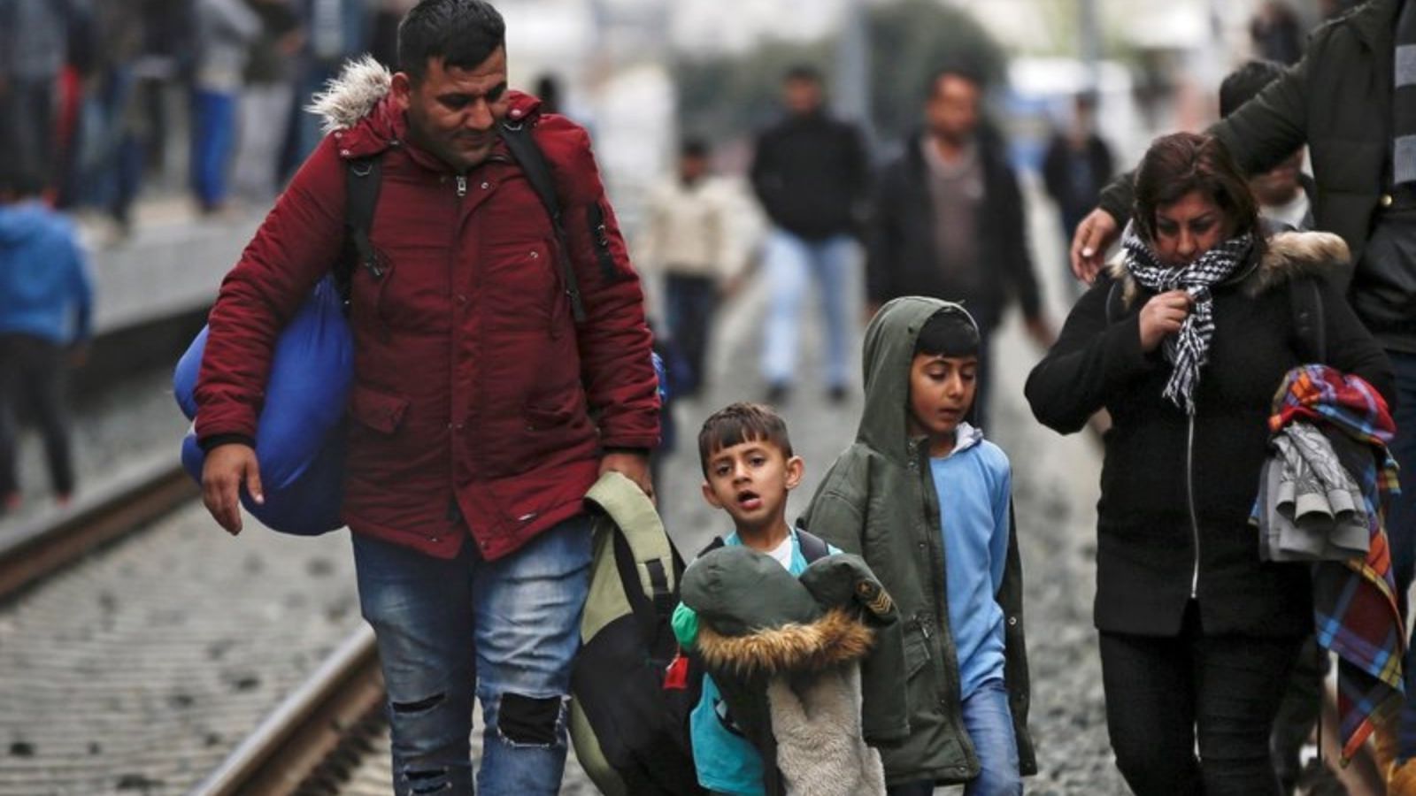 Refugiats caminen per les vies del tren