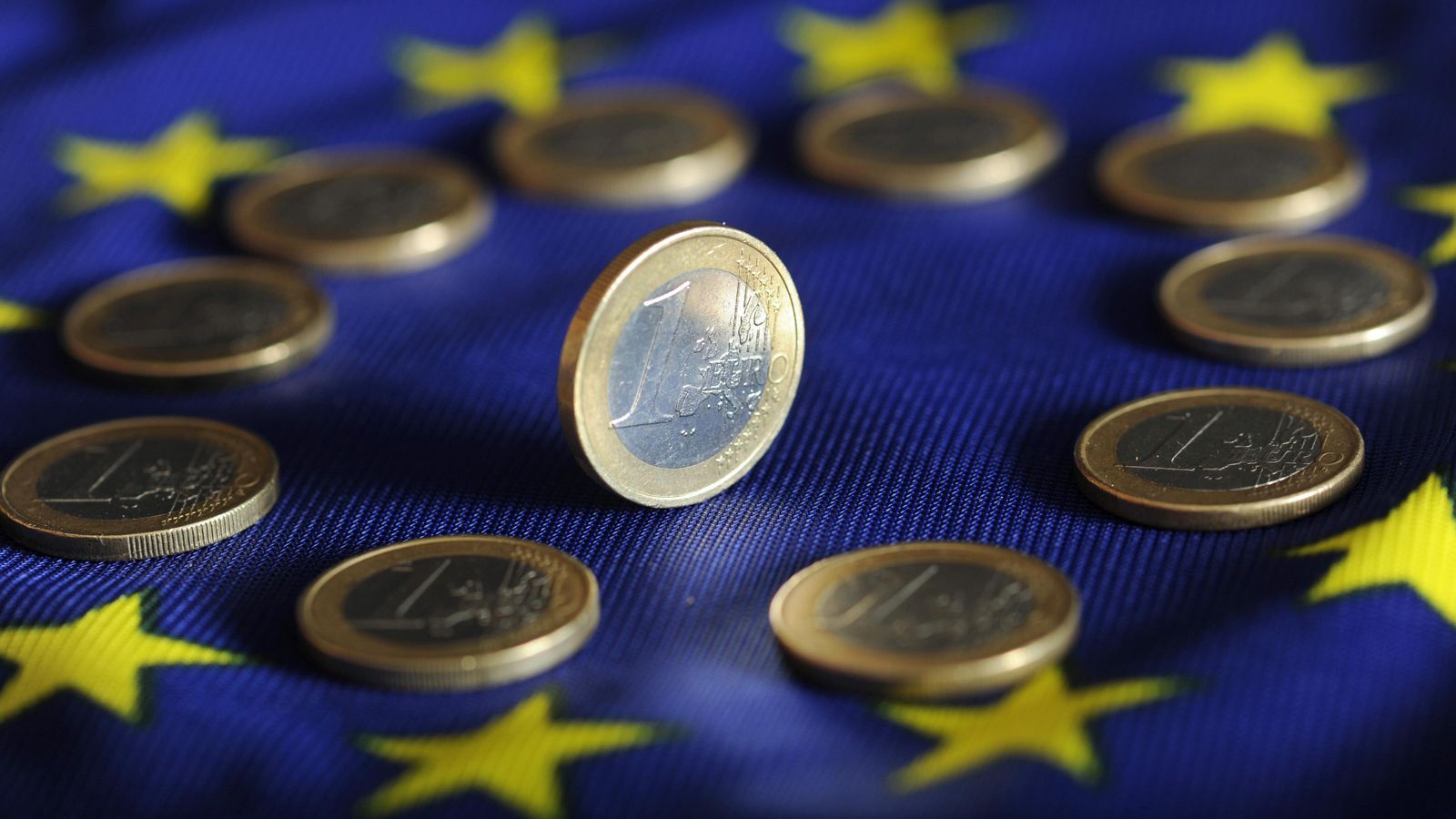 Moneda d'euro sobre una bandera europea.