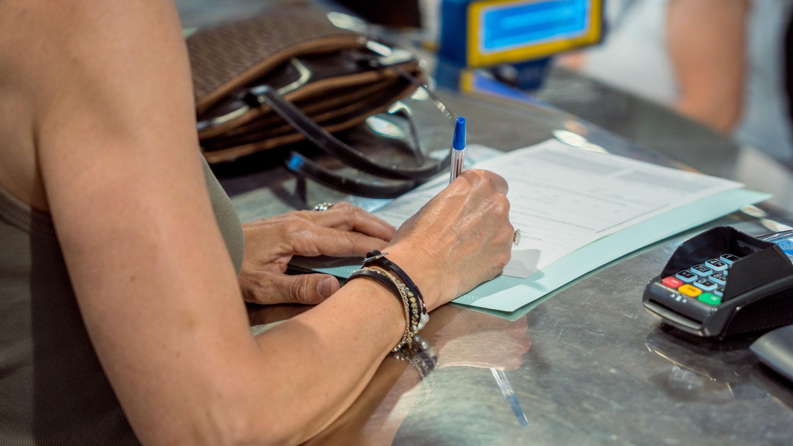 Una persona emplena un document per sol·licitar el vot per correu