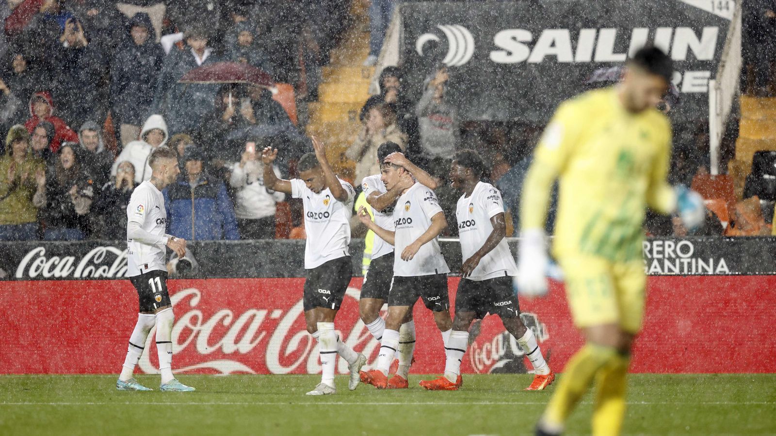 Els futbolistes del València celebren un gol sota la pluja a Mestalla