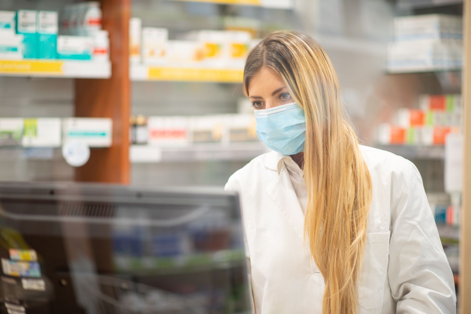 Una farmacèutica treballant amb la mascareta posada