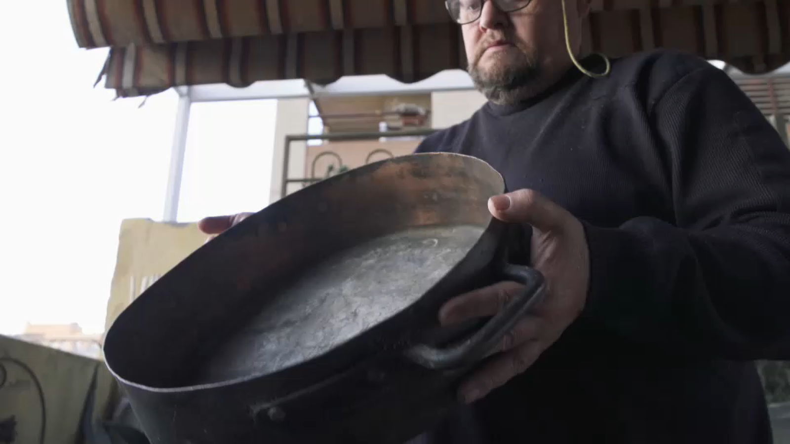 José Cuñat ens mostra un dels recipients amb els quals es cuinava la paella antigament