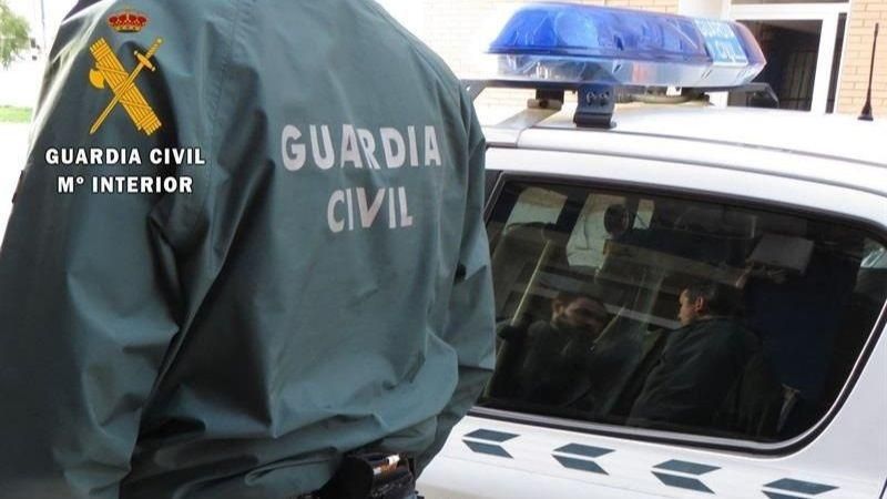 Un agent i un vehicle de la Guàrdia Civil, en una imatge d'arxiu Agent de la Guàrdia Civil