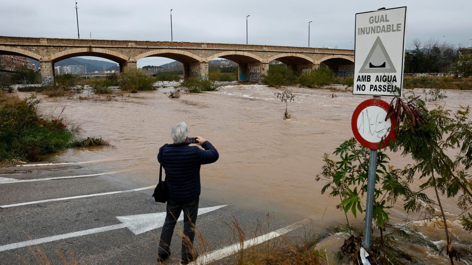 Un home fotografia el riu Palància al seu pas per Sagunt, este dimarts