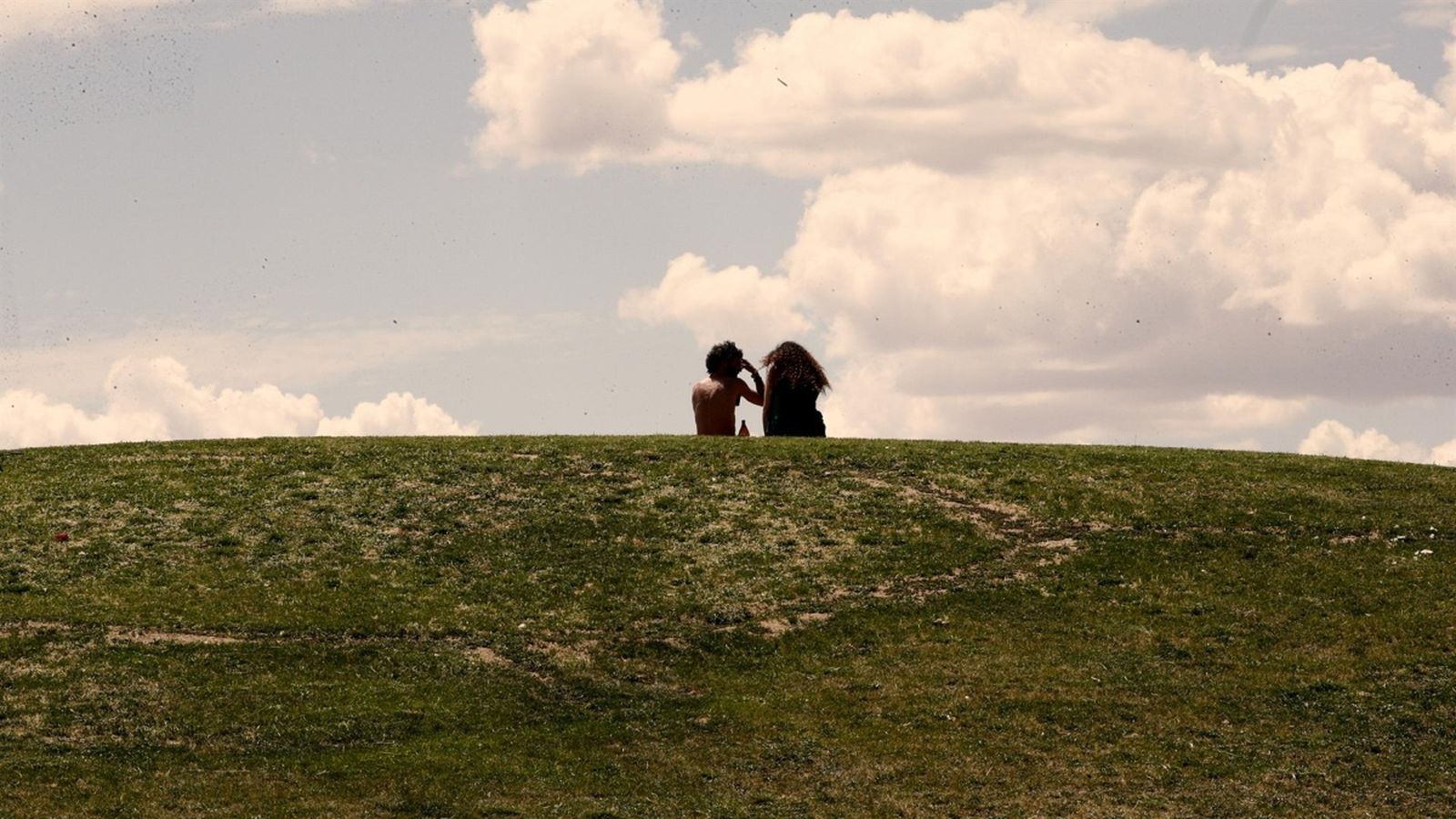 Dos persones joves passen el temps mirant els núvols