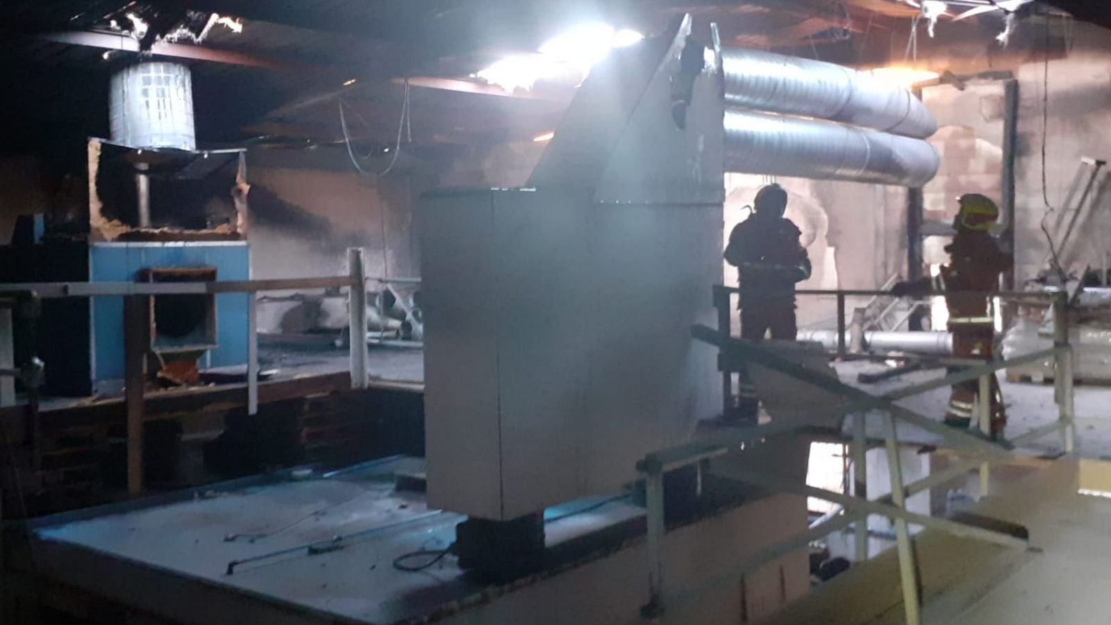 Els bombers treballant en l'extinció del foc a una fusteria de Catarroja