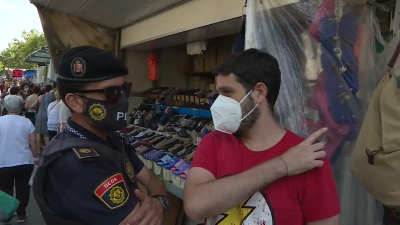 Un membre de l'UCO parla amb un jove a un mercat