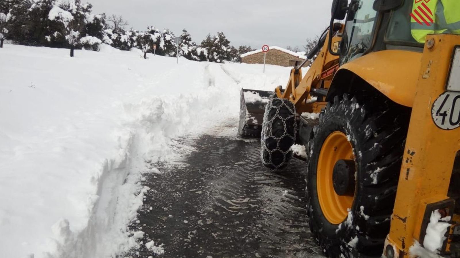 Un tractor llevant neu d'un camí
