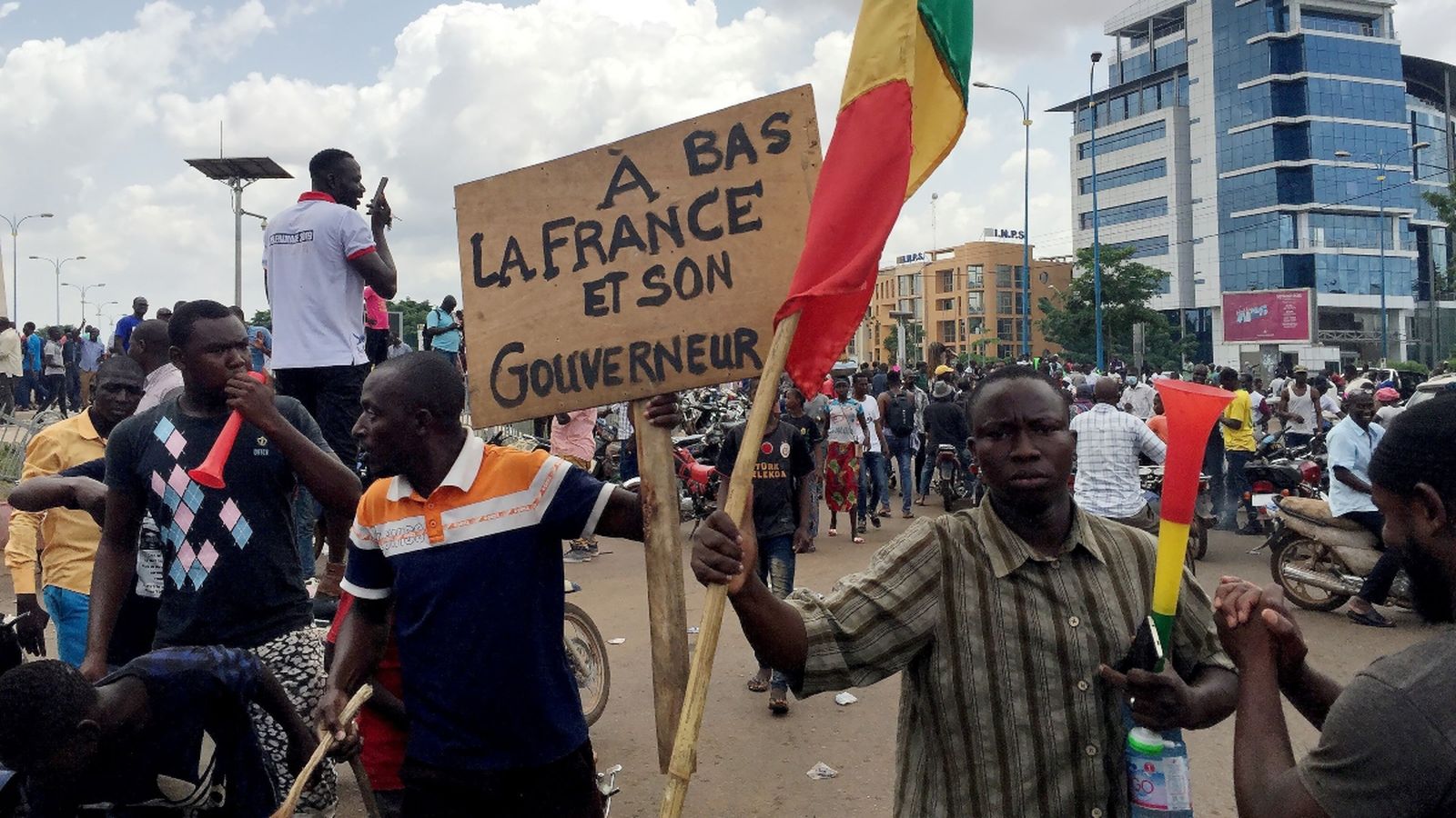 Partidaris del colp d’estat, aquest dimarts a la plaça de la Independència de Bamako. La pancarta diu: “Baix amb França i el seu governador”