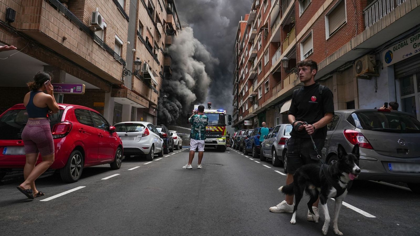 El veïnat contempla la densa fumeguera causada per l'incendi declarat al Tedi de l'avinguda del Port