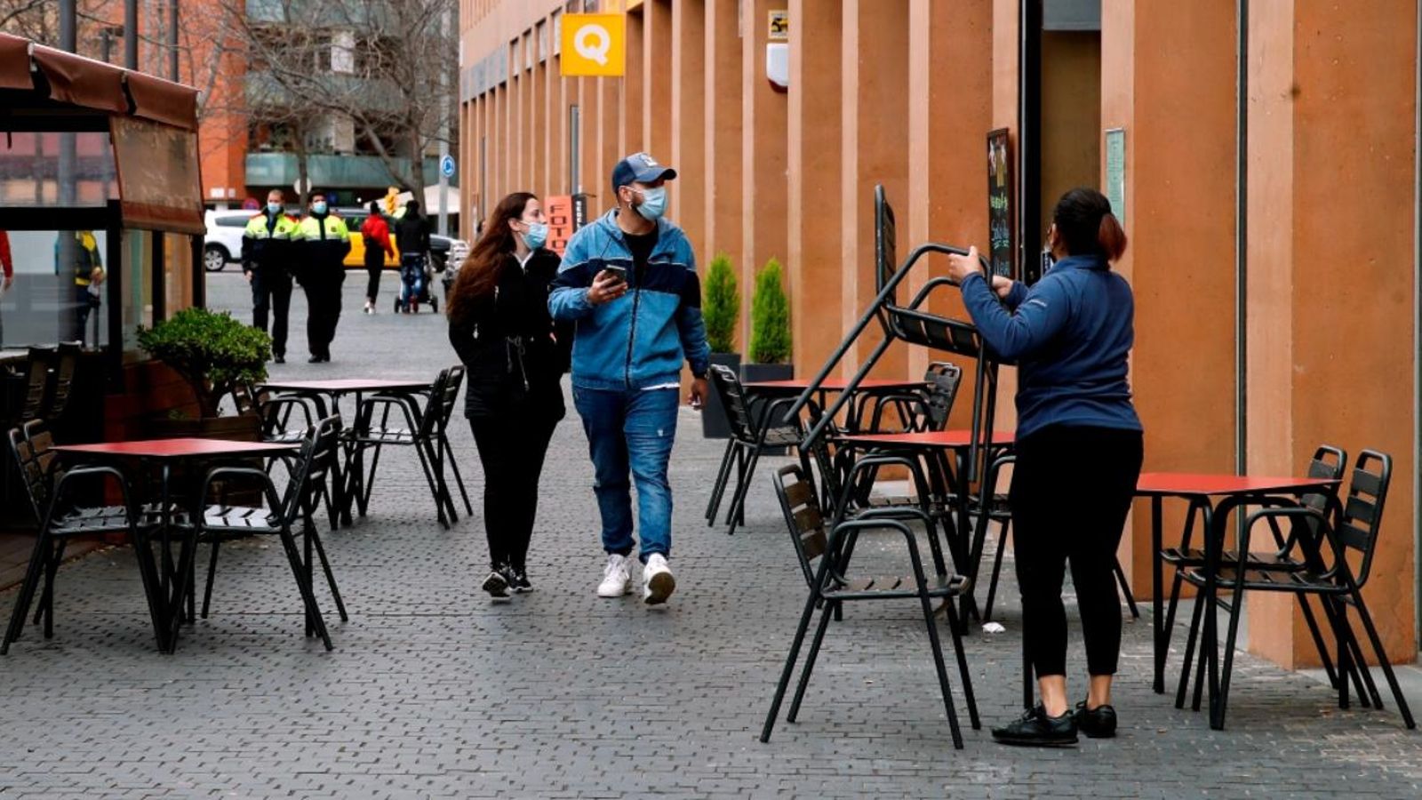 Una cambrera prepara la terrassa del restaurant on treballa per a atendre els seus clients en L'Hospitalet de Llobregat.