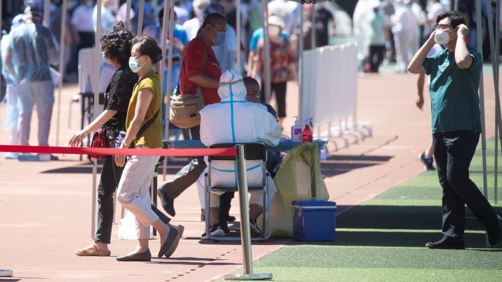 Professionals mèdics realitzen tests PCR en un estadi a Pequín