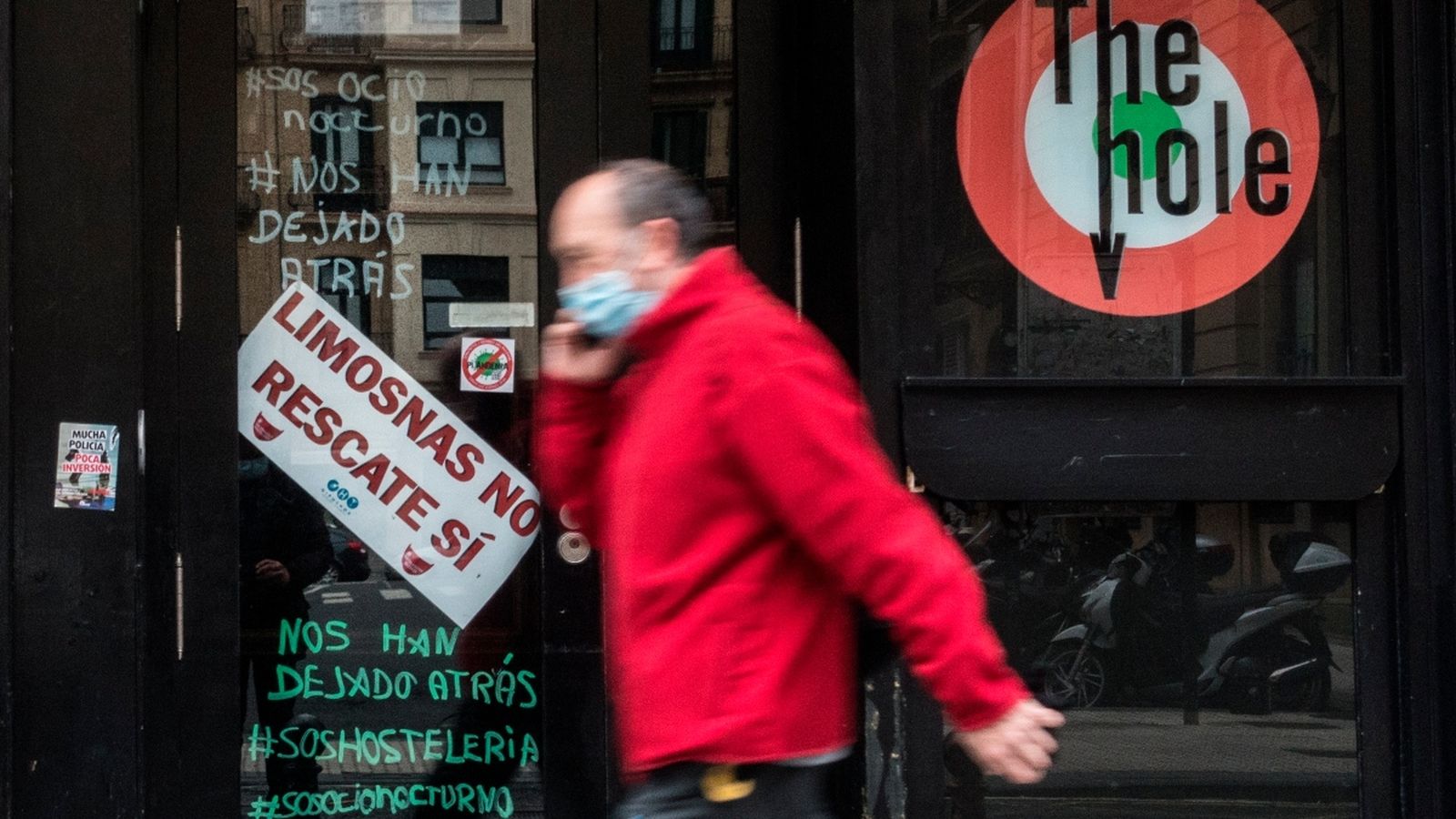 Un home camina al costat d'un establiment tancat a Sant Sebastià
