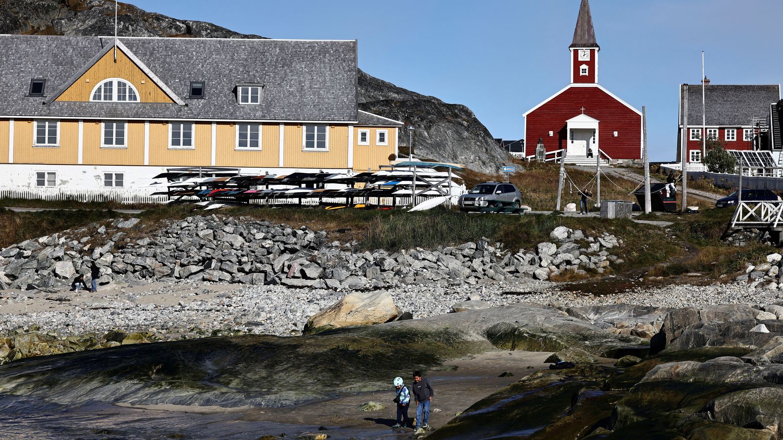 Dos xiquets juguen en una platja de la zona portuària de Nuuk, a Groenlandia
