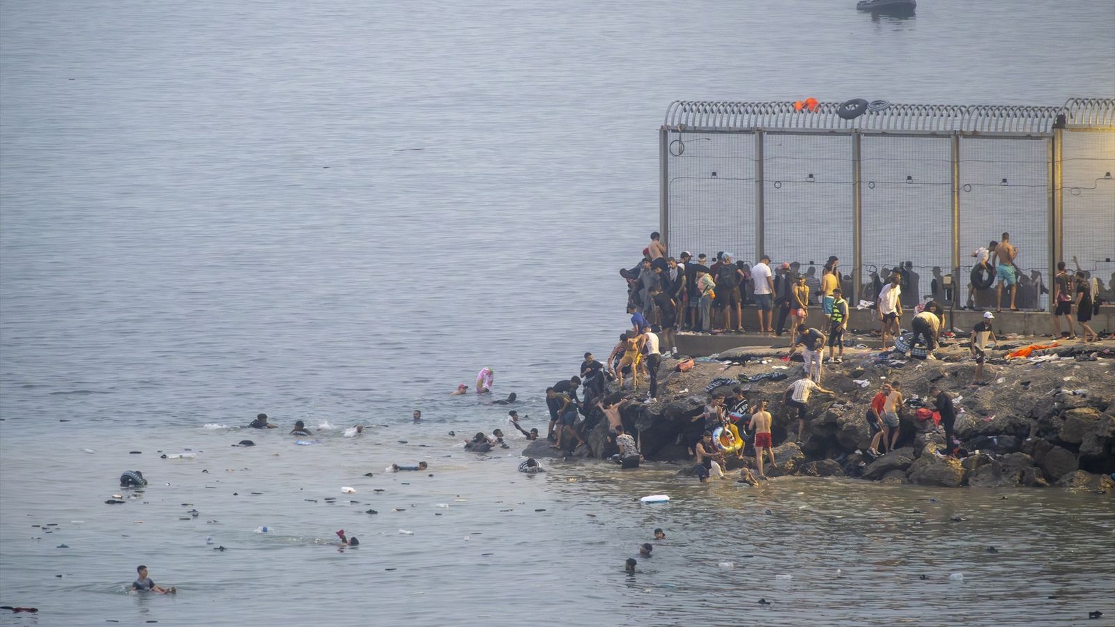 Diversos migrants entren a Ceuta a través de la línia fronterera de la platja