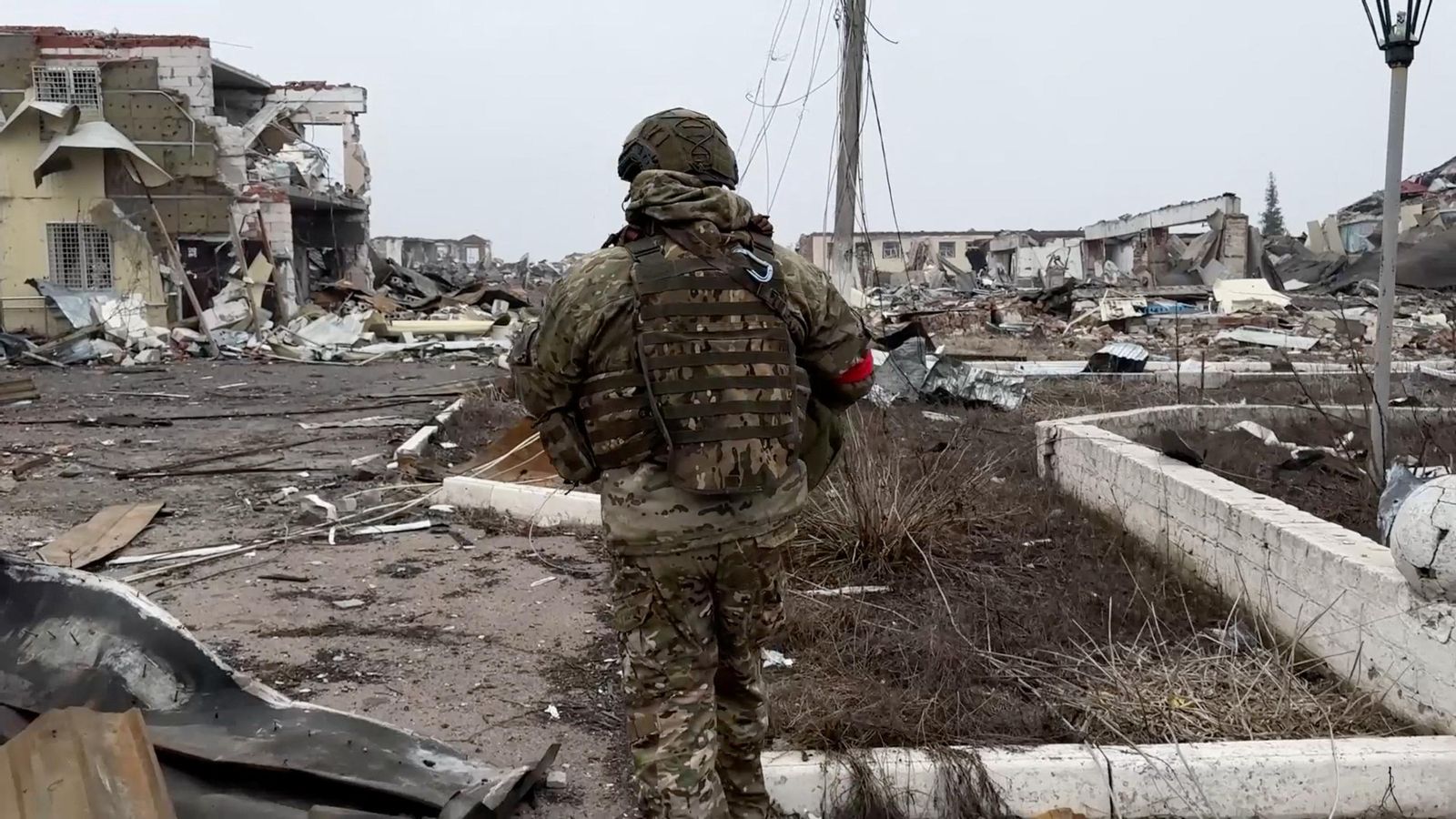 Un soldat de l'exèrcit rus camina per un carrer en ruïnes d'un assentament recuperat per les forces armades russes a la regió de Kursk, Rússia