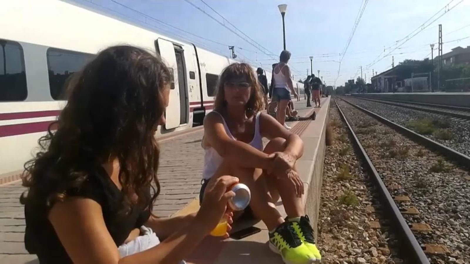 Viatgers esperant a les vies a l'estació de l'Hospìtalet de l'Infant