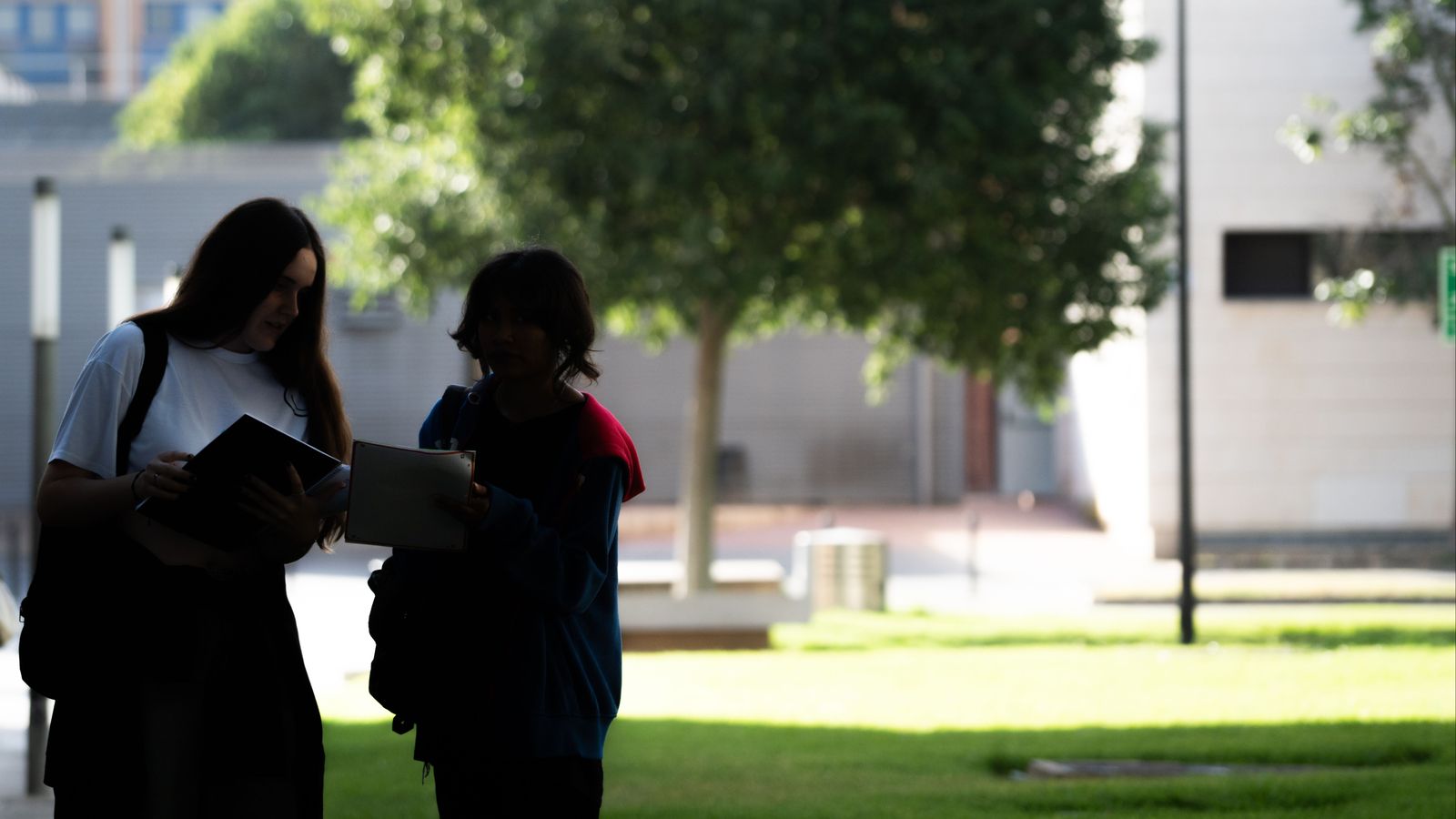 Dos alumnes que van fer la selectivitat en juny caminen per un campus universitari