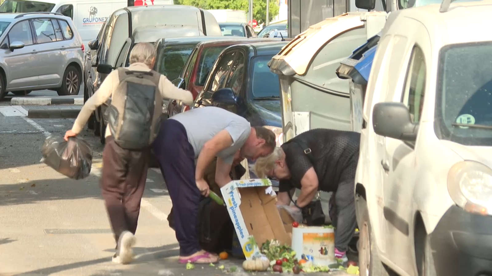 Gent buscant menjar en un contenidor