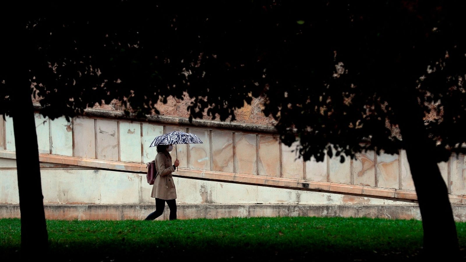 Una dona es protegeix de la pluja a València