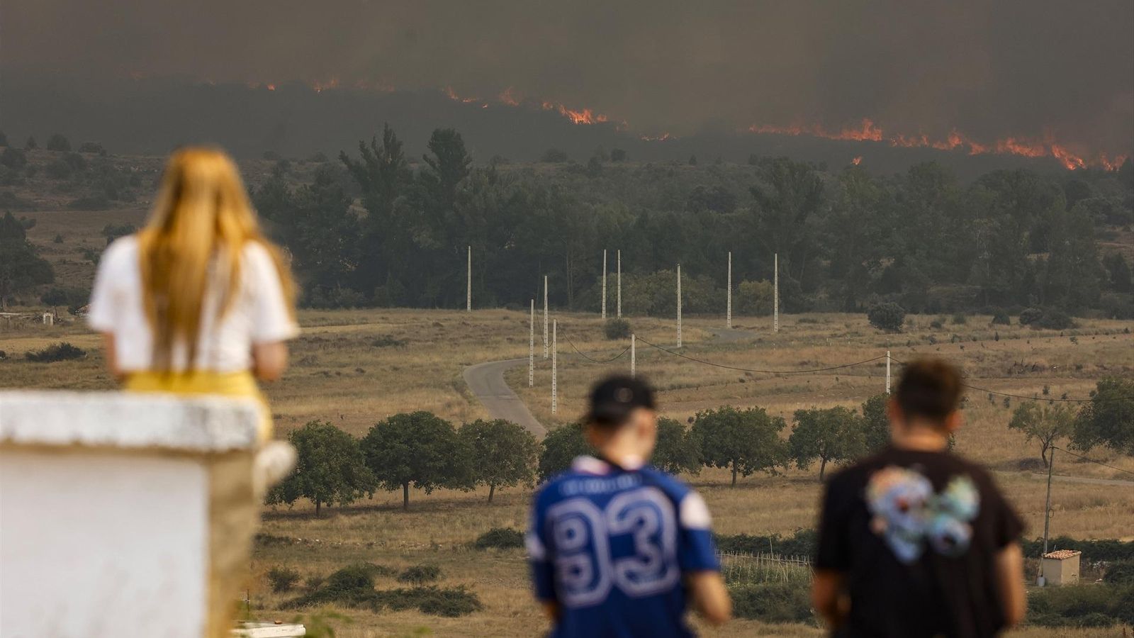 Diverses persones contemplen de lluny l'incendi de Begís