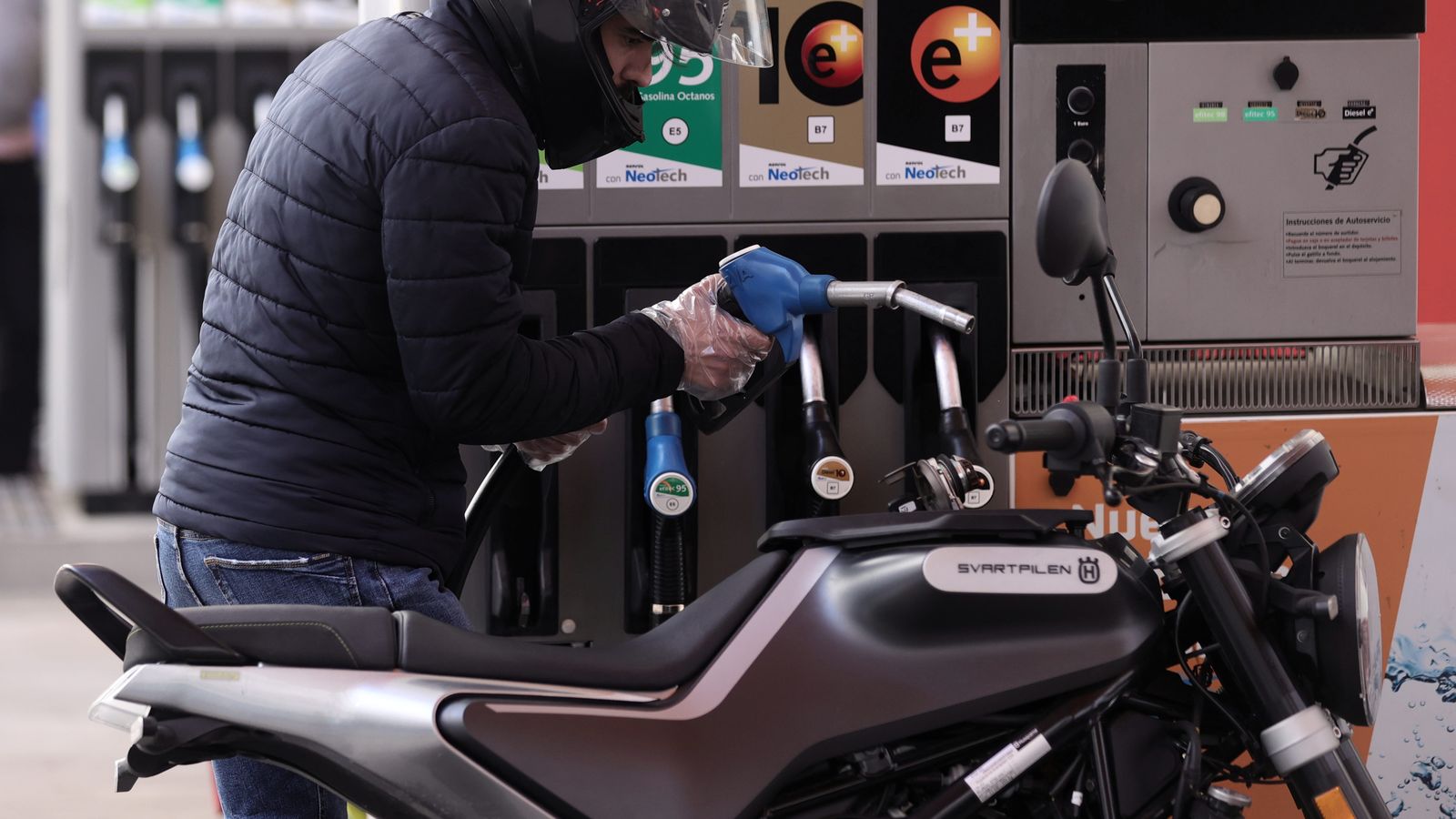 Un home reposta combustible en la seua moto