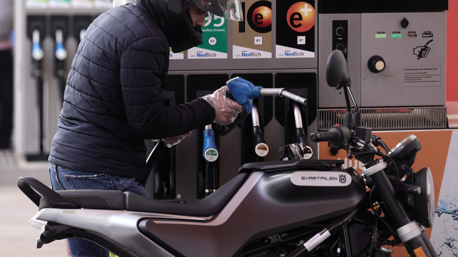 Un home reposta combustible en la seua moto Un home reposta combustible en la seua moto