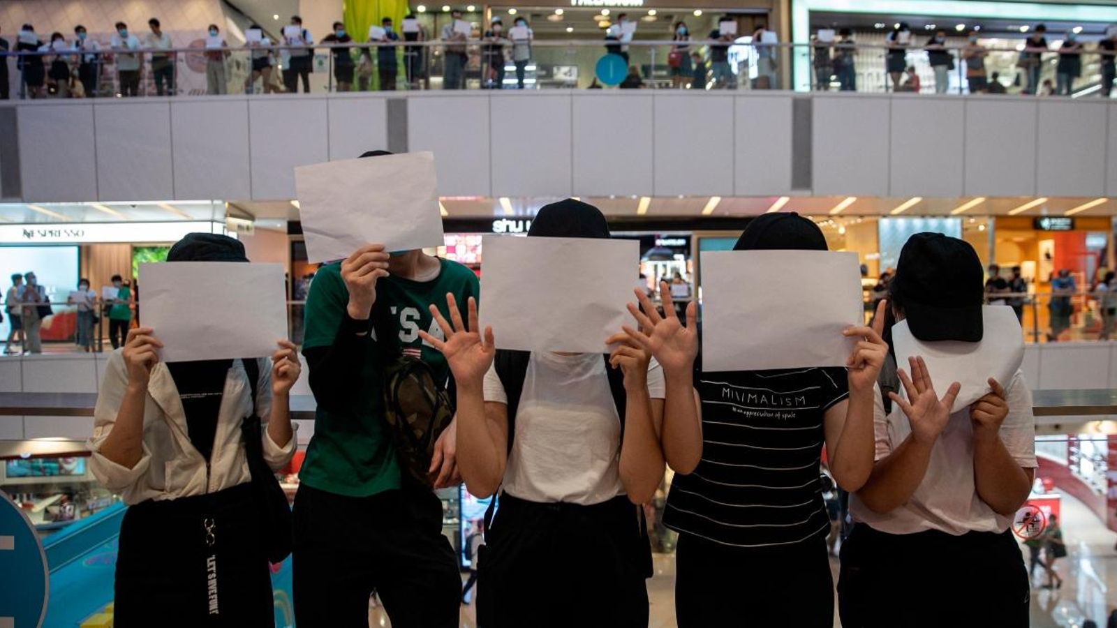 Manifestants exhibeixen fulls en blanc durant una protesta en un centre comercial a Hong Kong