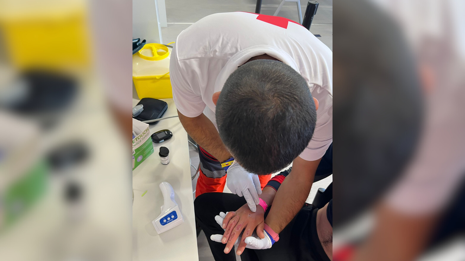 Un voluntari de Creu Roja atenent un dels menors que ha arribat en la pastera