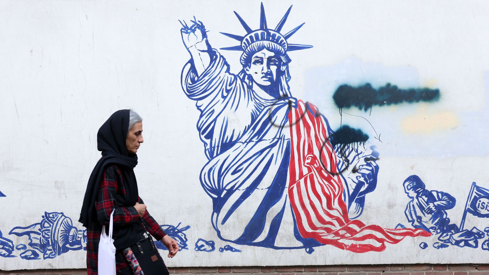 Una dona iraniana camina al costat d’un mural antieestatunidenc a Teherán, l'Irán, el 23 de febrer de 2026
