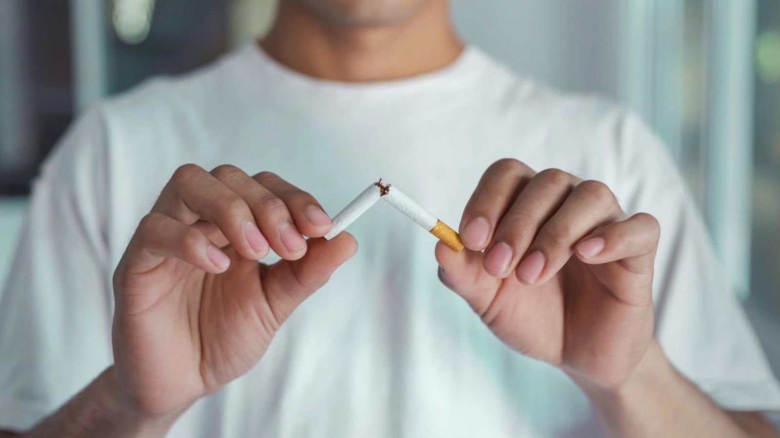 Una persona trencant un cigarret