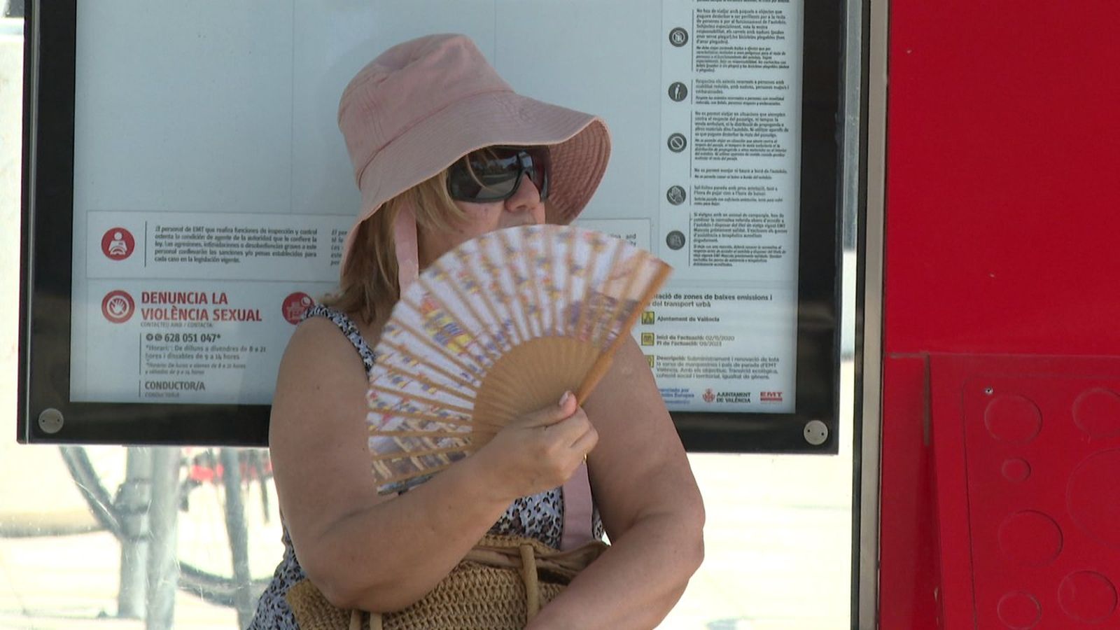 Una dona porta un ventall per a refrescar-se